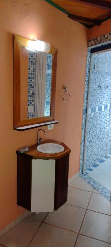 a bathroom with a sink and a mirror and a window at Waldhaus - A Pousada do Remo in Peruíbe