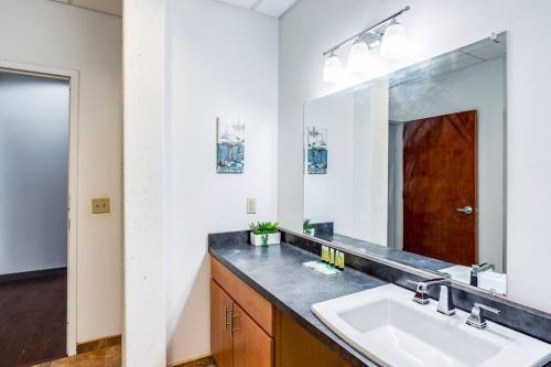 a bathroom with a sink and a large mirror at Centric NY Style Loft w/King bed in Rochester