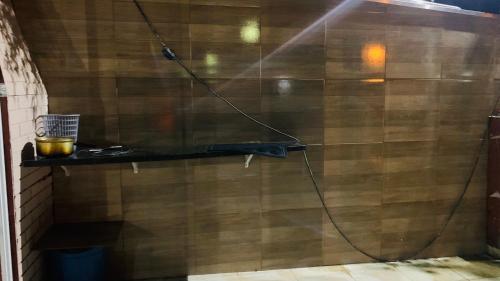 a shower with a hose attached to a wooden wall at Casa c piscina matinhos S Etiene in Matinhos