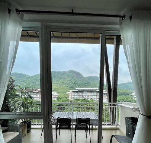 a room with a balcony with a table and chairs at 3BD/3BA Penthouse - Tropical Oasis in Pico de Loro in Patungan