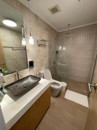 a bathroom with a sink and a toilet and a shower at 3BD/3BA Penthouse - Tropical Oasis in Pico de Loro in Patungan