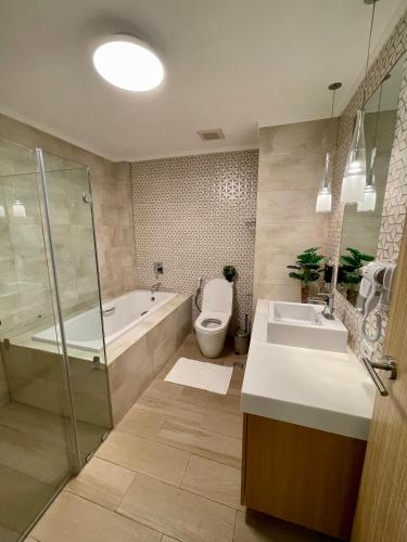 a bathroom with a tub and a toilet and a sink at 3BD/3BA Penthouse - Tropical Oasis in Pico de Loro in Patungan