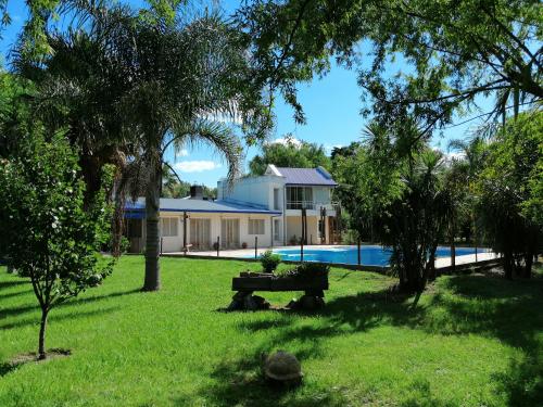 een huis met een zwembad en een bank in het gras bij El Sosiego in Roldán