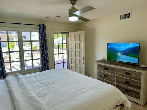 a bedroom with a bed and a flat screen tv at Hilltop Villa, Pool, Hot tub, Views, Avocado Grove in Fallbrook