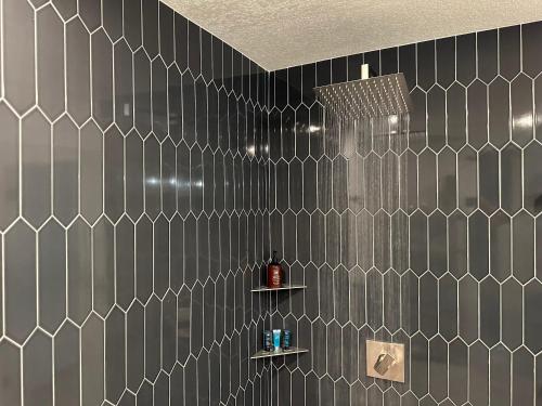 a bathroom with a black and white tiled wall at Hilltop Villa, Pool, Hot tub, Views, Avocado Grove in Fallbrook