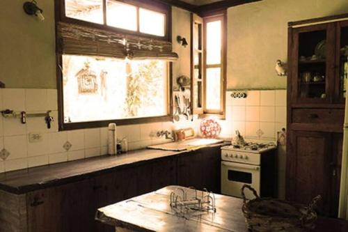 a kitchen with a sink and a stove and a window at LOS CHAÑARES CASAS DE CAMPO in Rama Caída
