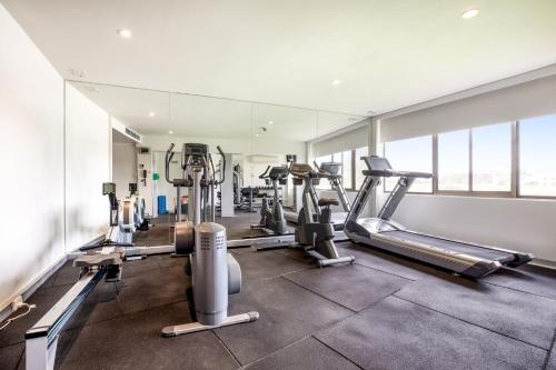 a gym with several treadmills and cardio machines at Holiday Inn Melbourne Airport, an IHG Hotel in Melbourne