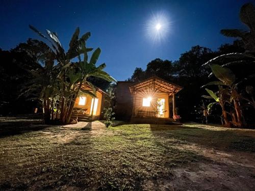 Una casa de noche con la luna en el cielo en Pousada Flor de Laranjeira, en Goiás