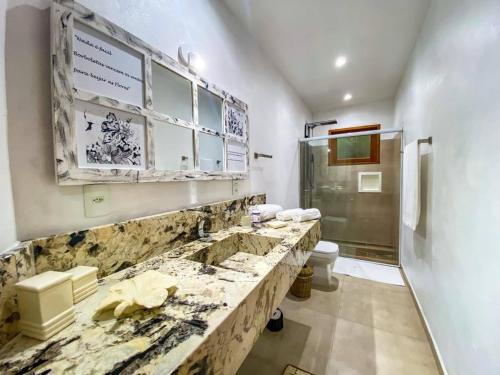 y baño con lavabo de mármol y ducha. en Casa com quintal arborizado e lazer em Trancoso, en Porto Seguro