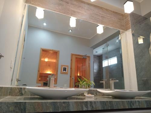 baño con 2 lavabos y espejo grande en Silver Inn Hotel, en Cerro Azul