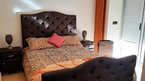 a bedroom with a large bed with a large headboard at Salòs del Comfort in Oualidia