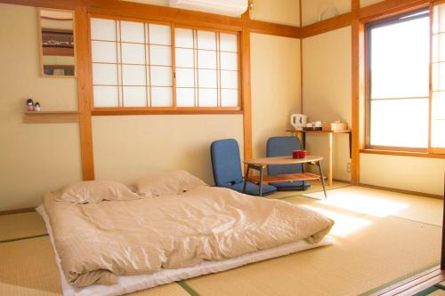 um quarto com uma cama, uma mesa e duas cadeiras em 幽舍の庭 em Izumi-Sano