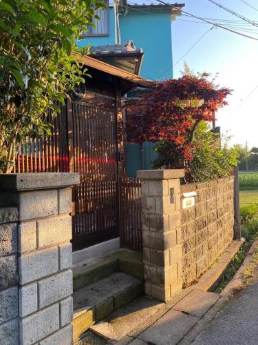 a house with a gate and stairs in front of it at 幽舍の庭 in Izumi-Sano