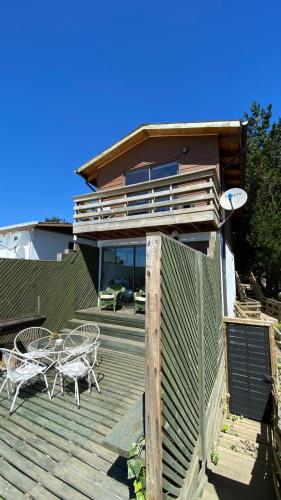 une maison dotée d'une terrasse avec deux chaises et une table dans l'établissement Casa Linda vista, à Curanipe