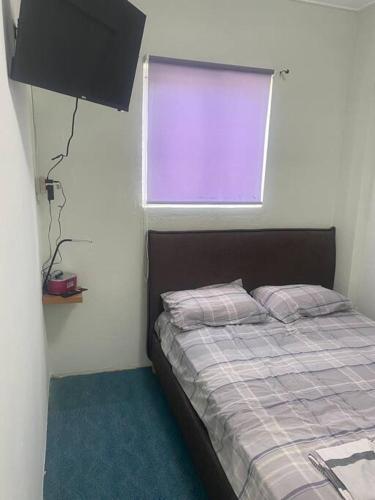 Dormitorio pequeño con cama y ventana en Curacao Cozy Apartment, en Willemstad