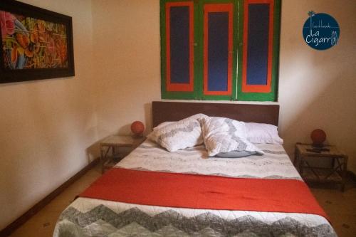 a bedroom with a bed with a colorful window at La Cigarra Casa de Huéspedes in Salento