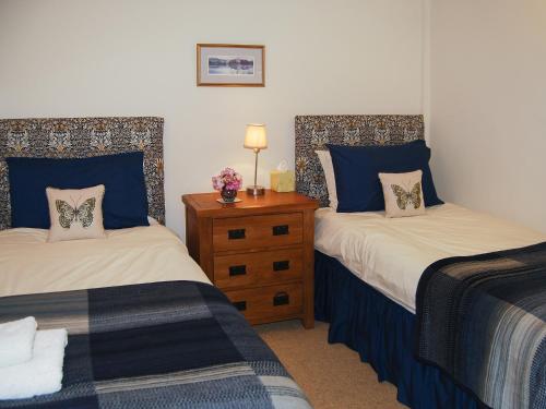 a bedroom with two beds with blue and white sheets at Blencathra in Mungrisdale