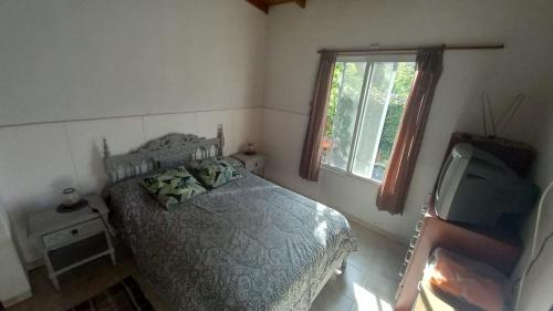 1 dormitorio con 1 cama y TV. en Casa en Colinas Verdes en Sierra de los Padres