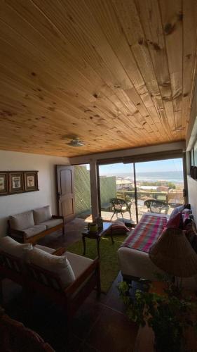 a living room with a wooden ceiling and a couch at Casa Linda vista in Curanipe