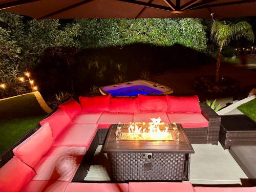 a patio with a red couch and a table at Hilltop Villa, Pool, Hot tub, Views, Avocado Grove in Fallbrook