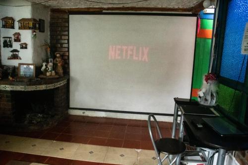 a large screen with the words netflix on a wall at La Cigarra Casa de Huéspedes in Salento