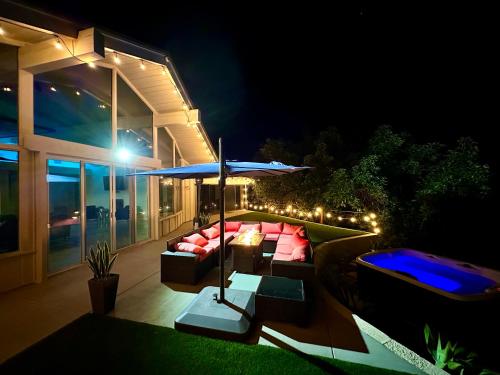 a patio with a couch and an umbrella at night at Hilltop Villa, Pool, Hot tub, Views, Avocado Grove in Fallbrook