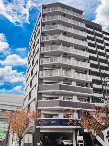 a tall building with a car parked in front of it at Coco Fukuoka Chiyo in Fukuoka