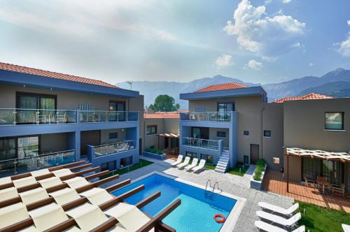 a view of a house with a swimming pool and chairs at Mary's Residence Suites in Chrysi Ammoudia