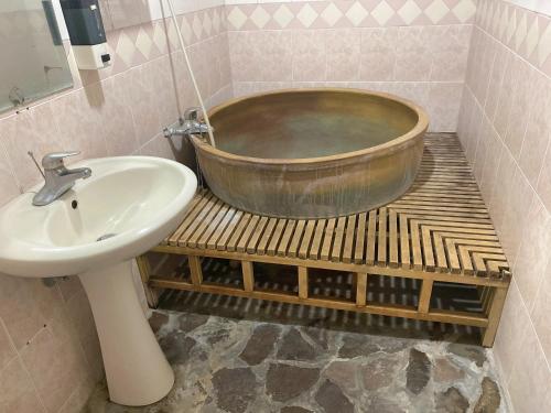 y baño con lavabo y bañera de cobre. en Yushan House B&B, en Xinyi