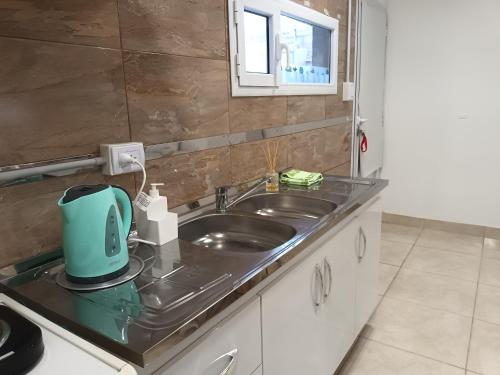 a kitchen with a sink and a blue appliance on a counter at Bethel Alojamiento in Zapala