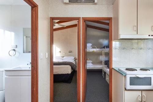 a small room with a bed and a kitchen at NRMA Bathurst Panorama Holiday Park in Bathurst