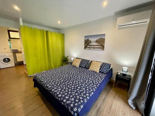 um quarto com uma cama e uma cortina verde em Tunui City Apartment - Quiet & Pool em Papeete