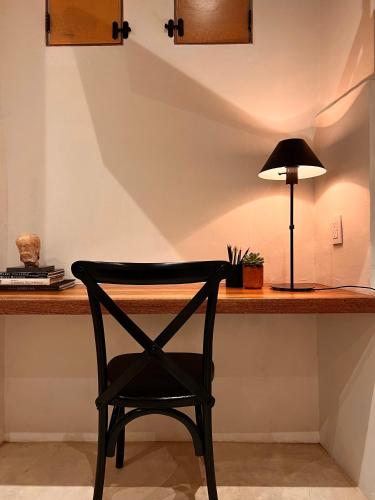 a black chair sitting at a desk with a lamp at Hotel Atia in Guadalajara