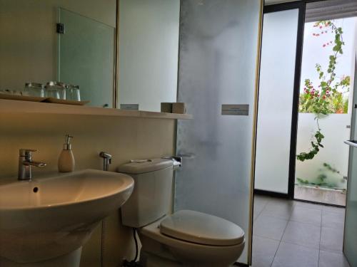 a bathroom with a toilet and a sink and a mirror at Oceanami Resort Sea View in Long Hai