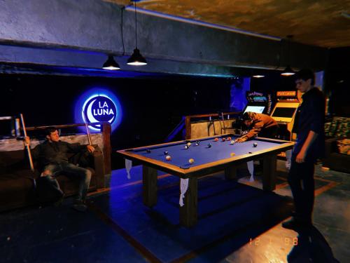a group of men playing pool in a room at Hosteria de la Villa - Moonski in San Carlos de Bariloche