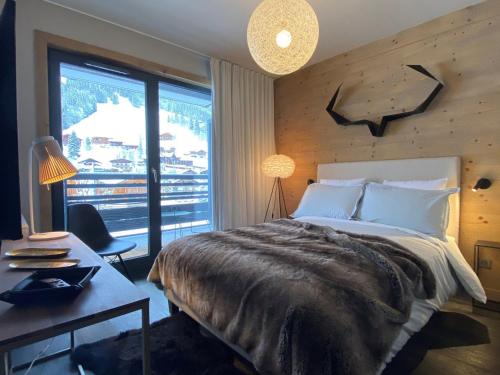 ein Schlafzimmer mit Bett, Schreibtisch und Fenster in der Unterkunft Appartement standing 100m², pied des pistes, 8 pers, terrasse, WiFi, parking - FR-1-598-43 in Les Gets