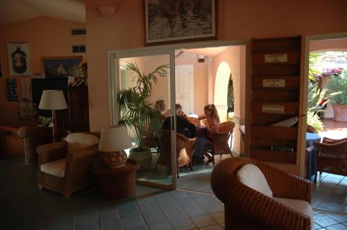 a group of people sitting at a table in a living room at Residence Fenicia in Villasimius