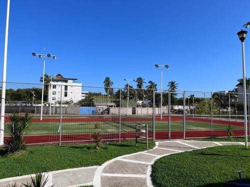 a tennis court in a park with a fence at Hermoso Departamento Entero Planta Baja in Acapulco