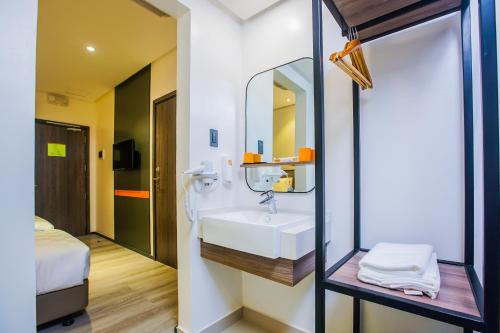 Go Hotels Plus Naga في نجا: حمام مع حوض ومرآة