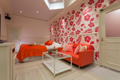 a bedroom with a red couch and a bed at Restay Kochi (Adult Only) in Kochi