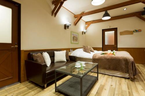 a hotel room with a bed and a couch at Restay Kochi (Adult Only) in Kochi