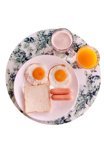 a plate of eggs and bread and orange juice at Retro Box Hotel Chumphon in Chumphon