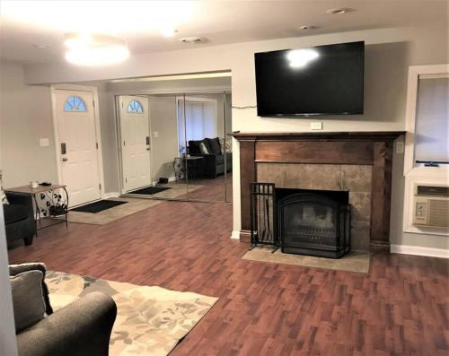 a living room with a fireplace and a flat screen tv at 2BR Lake House 40ft Dock Access in Keego Harbor
