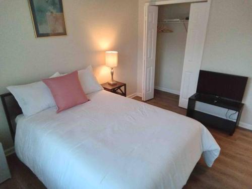 Een bed of bedden in een kamer bij Elegant 4 bedroom house with community pool & deck