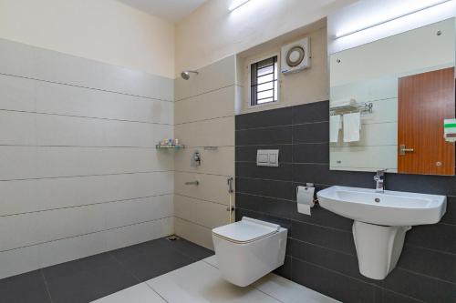 a bathroom with a toilet and a sink at StayVista at Anjali with Free Breakfast & Terrace Access in Kozhikode