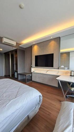 a hotel room with a bed and a flat screen tv at Aston Apartment Batam Floor 21 in Nagoya