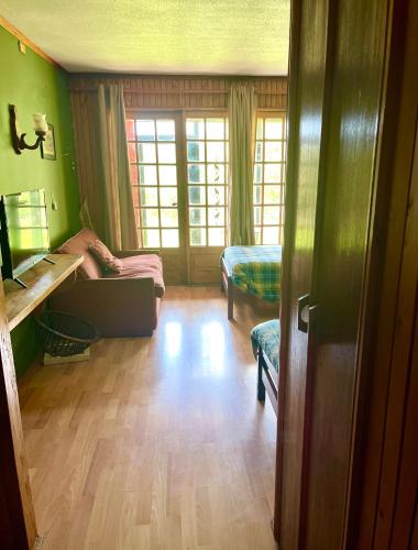 a room with green walls and a wooden floor at Alojamiento 2 camas con baño privado y terraza in Ancud