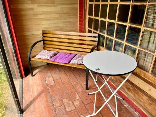 a table and a bench on a patio at Alojamiento 2 camas con baño privado y terraza in Ancud