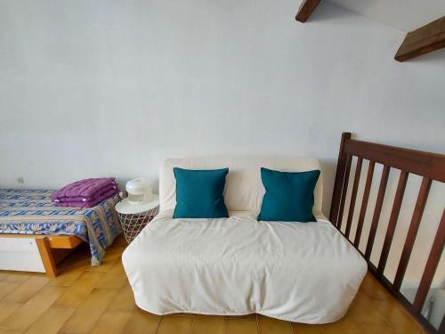 een bed met twee blauwe kussens in een kamer bij Appartement Marseillan-Plage, 2 pièces, 5 personnes - FR-1-326-777 in Marseillan