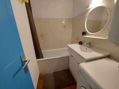 een badkamer met een wastafel, een spiegel en een bad bij Appartement Marseillan-Plage, 2 pièces, 5 personnes - FR-1-326-777 in Marseillan